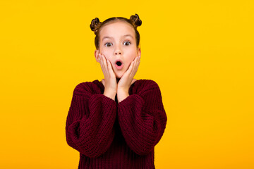 Photo of speechless schoolkid arms touch cheeks open mouth cant believe empty space isolated on yellow color background - obrazy, fototapety, plakaty