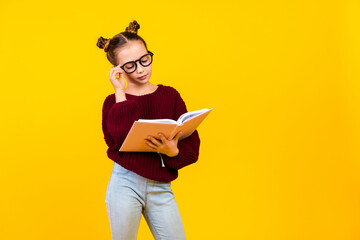 Photo of smart little schoolkid hand touch eyeglasses read book empty space isolated on yellow color background