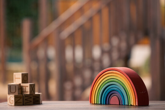 Brightly coloured wooden rainbow learning puzzle in nature-based playground environment