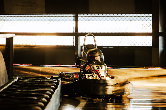 Boy driving Go Kart on indoor race track circuit