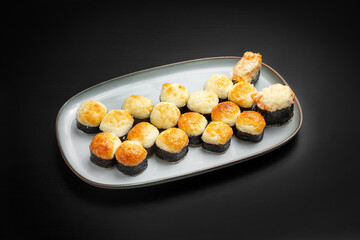Sushi set, rolls, assorted baked rolls. On a black background.