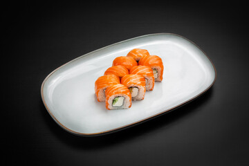 Sushi, Philadelphia rolls with cucumber. On a black background.
