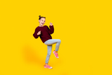 Fototapeta na wymiar Full body photo of overjoyed positive schoolchild have fun dancing empty space isolated on yellow color background