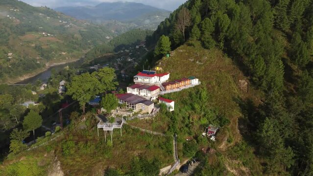 Rotating drone over cottages on a green forest mountain in Mussoorie,Uttarakhand, India