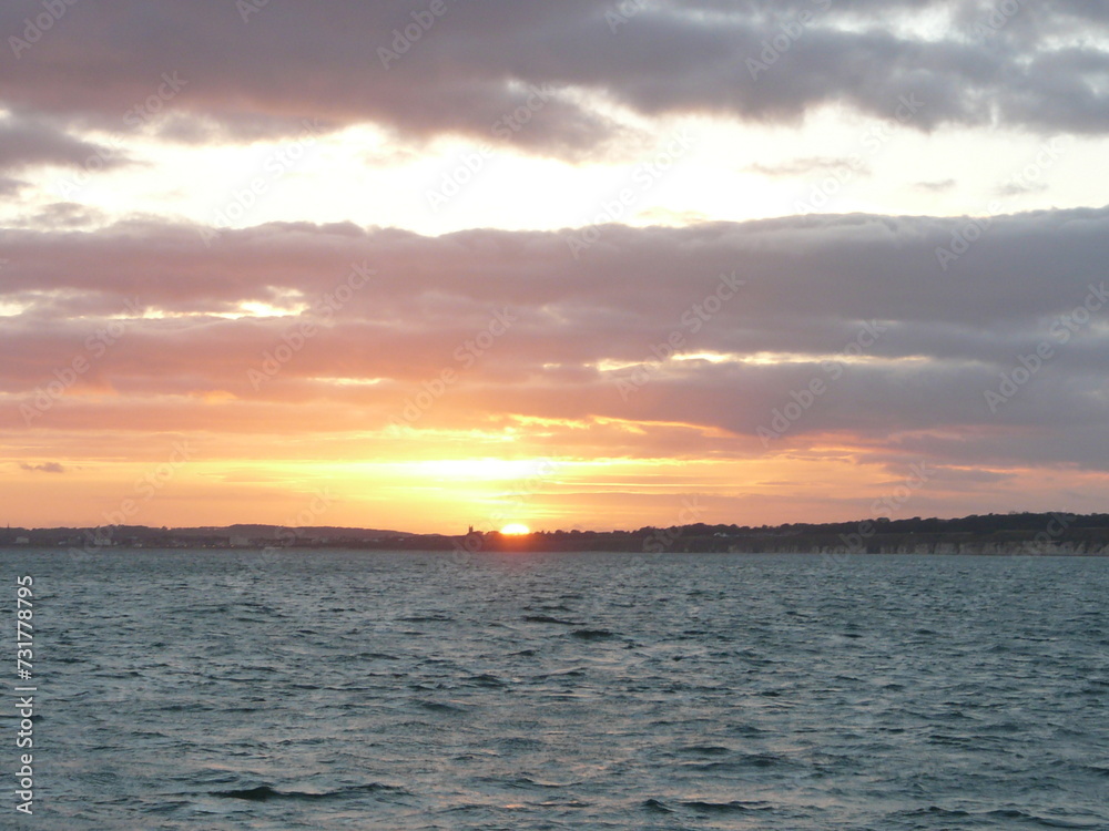 Wall mural Sunset over the seaside town of Bridlington, UK, as taken from a boat out at sea