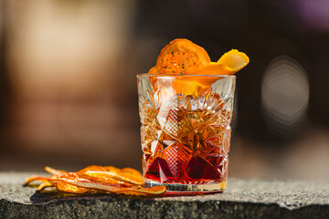 Delicious old fashion cocktail in the etched glass with ice and orange slices. Shallow dof.