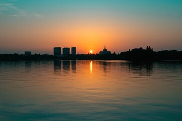 Naklejka premium the sunset reflects on the water in the distance with a cityscape visible