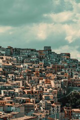 Obraz premium Scenic view of a residential area in Cammarata and cloud-filled sky in the background