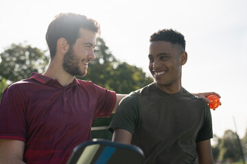 Smiling men talking in pickleball court