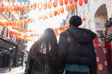 Rear view of two women walking in Chinatown