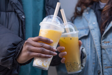 Close up of two women holding bubble tea 