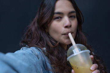 Portrait of cheerful young woman drinking bubble tea