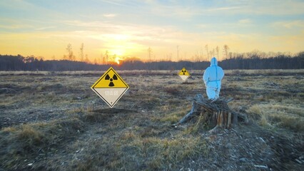 Virologist wearing hazard protective suite and gas mask on contaminated land after using Biological...