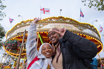 UK, London, Portrait of female tourists in hijabs in front of merry-go-round