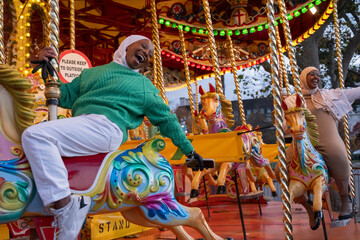Fototapeta na wymiar Young female tourists in hijabs on merry-go-round