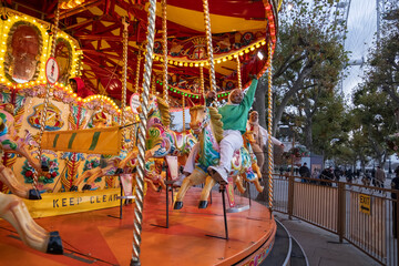 Young female tourists in hijabs on merry-go-round