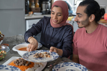 Mid adult couple eating meal at home