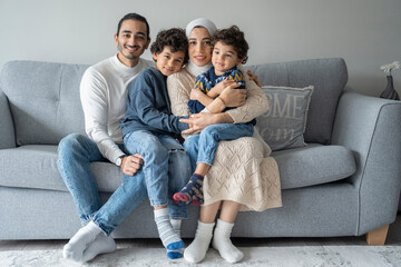 Portrait of parents and sons (2-3, 6-7) sitting on sofa