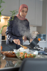 Woman in hijab preparing meal at home