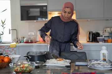 Woman in hijab preparing meal at home