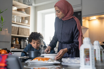 Mother and son (6-7) preparing meal at home