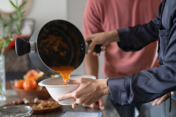 Mid adult couple preparing meal at home