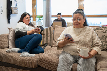 Three-generation family sitting in living room