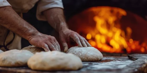 Zelfklevend Fotobehang baker's hands sprinkled with flour, kneading dough on the table for baking bread in a woodfired oven, poster © Dmitriy