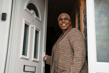 Mature woman standing at front door © Cultura Creative