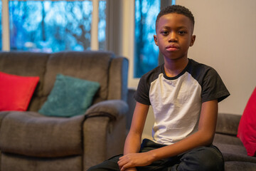 Portrait of boy sitting on sofa in living room © Cultura Creative