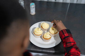 Boy preparing cupcakes at home