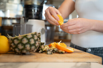 Woman slicing fruit in kitchen, close up - obrazy, fototapety, plakaty