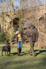 Happy couple on walk with dog in park