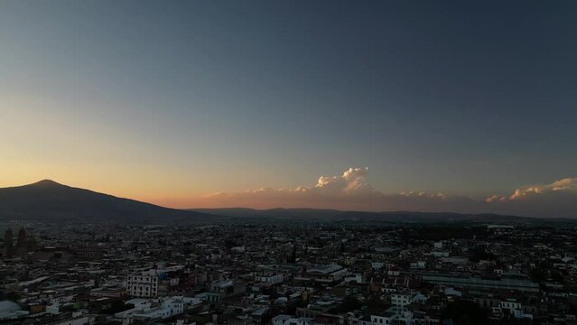 Drone footage of beautiful sunset over the mountains and the city of Morelia in Michoacan, Mexico