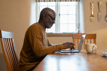 Senior man using laptop at home