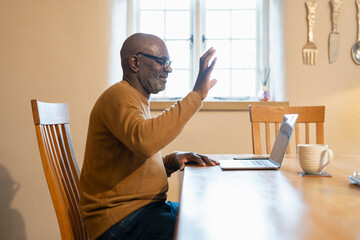 Senior man having video call on laptop at home