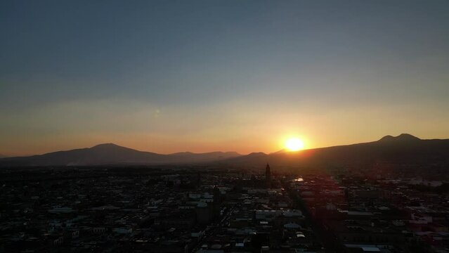 Drone footage of beautiful sunset over the mountains and the city of Morelia in Michoacan, Mexico