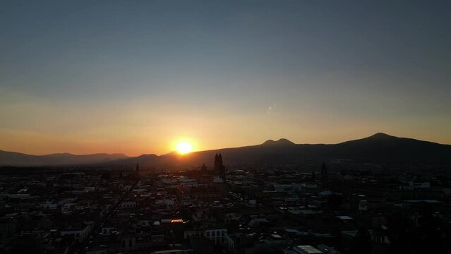Drone footage of beautiful sunset over the mountains and the city of Morelia in Michoacan, Mexico