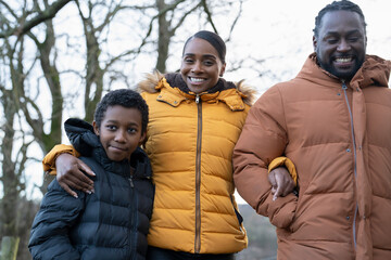 Boy with parents in winter jackets walking in rural setting
