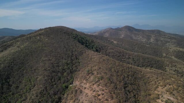 Drone flying over beautiful landscape with mountains, blue sky and sunlight in central Mexico