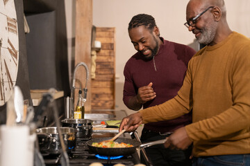 Two men preparing food in kitchen