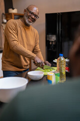 Senior man preparing meal in kitchen