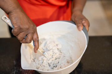 Senior woman preparing dough on kitchen counter - obrazy, fototapety, plakaty