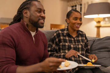 Fototapeta na wymiar Mid adult couple eating meal in living room