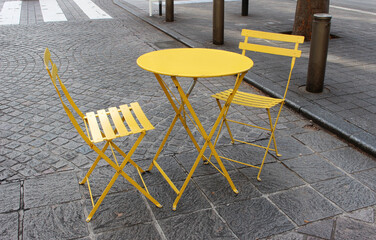 Modern outdoor table with two chairs on the sidewalk