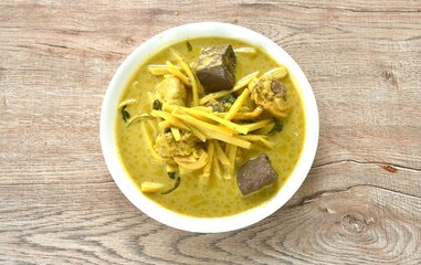 spicy boiled slice fresh bamboo shoot with chicken and blood in coconut milk curry soup on plate 