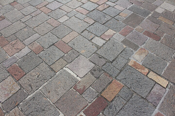 Texture of combination of different size square cobblestones. Pattern of sidewalk tiles in the street. 