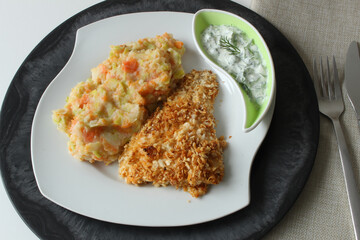 Backed Fish with mashed potatoes and mashed vegetables served on a plate