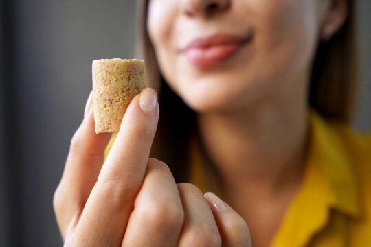 Peanut candy (pa&ccedil;oca or pacoca). Extreme close-up of beautiful girl holding Pacoca traditional Brazilian peanut-based candy.