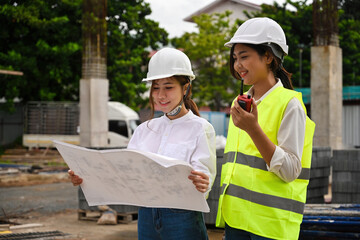 Two of civil engineers inspecting building at construction site